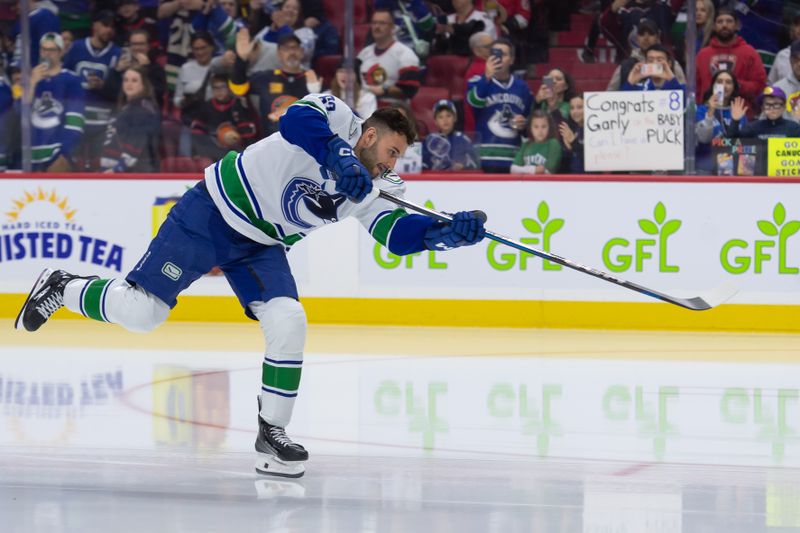 Nov 23, 2024; Ottawa, Ontario, CAN; Vancouver Canucks center Max Sasson (63) shoots the puck during warmup prior to game against the against the Ottawa Senators at the Canadian Tire Centre. Mandatory Credit: Marc DesRosiers-Imagn Images