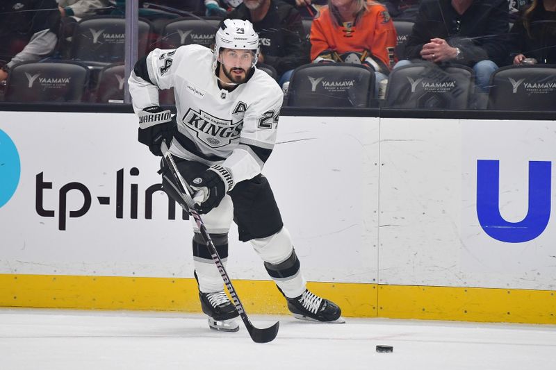 Nov 29, 2024; Anaheim, California, USA; Los Angeles Kings center Phillip Danault (24) moves the puck against the Anaheim Ducks during the first period at Honda Center. Mandatory Credit: Gary A. Vasquez-Imagn Images