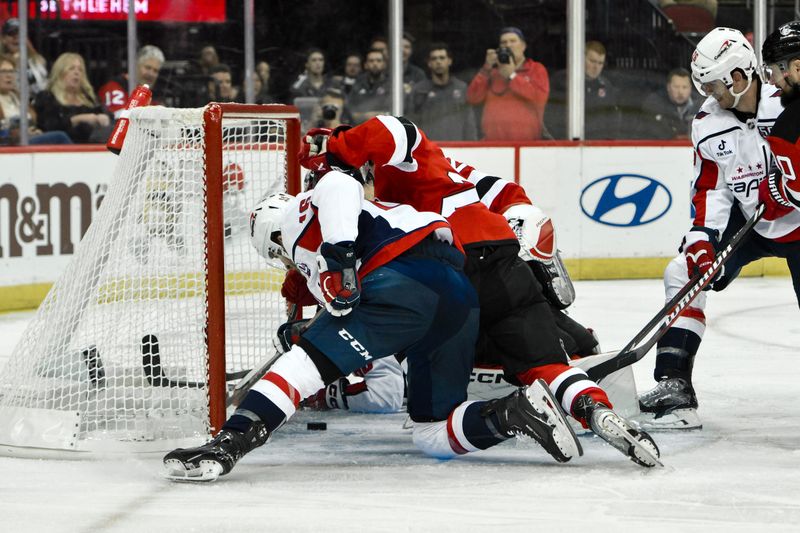 Oct 19, 2024; Newark, New Jersey, USA; Washington Capitals right wing Taylor Raddysh (16) tries to gain control of the puck against New Jersey Devils defenseman Seamus Casey (24) during the third period at Prudential Center. Mandatory Credit: John Jones-Imagn Images