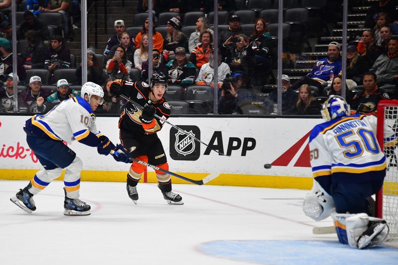 Apr 7, 2024; Anaheim, California, USA; Anaheim Ducks defenseman Olen Zellweger (51) shoots on goal against St. Louis Blues center Brayden Schenn (10) and goaltender Jordan Binnington (50) during the overtime period at Honda Center. Mandatory Credit: Gary A. Vasquez-USA TODAY Sports