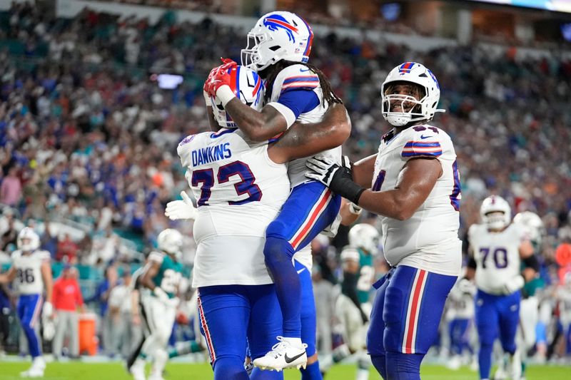 Buffalo Bills running back James Cook (4), center, celebrates his touchdown during the first half of an NFL football game Miami Dolphins, Thursday, Sept. 12, 2024, in Miami Gardens, Fla. (AP Photo/Rebecca Blackwell)