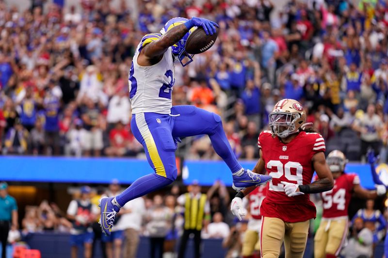 Los Angeles Rams running back Kyren Williams, left, jumps in for a touchdown as San Francisco 49ers safety Talanoa Hufanga watches during the first half of an NFL football game Sunday, Sept. 17, 2023, in Inglewood, Calif. (AP Photo/Ashley Landis)