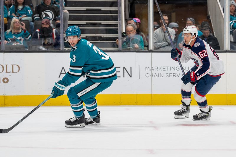 Nov 5, 2024; San Jose, California, USA;  San Jose Sharks defenseman Henry Thrun (3) controls the puck against Columbus Blue Jackets right wing Kevin Labanc (62) during the first period at SAP Center at San Jose. Mandatory Credit: Neville E. Guard-Imagn Images