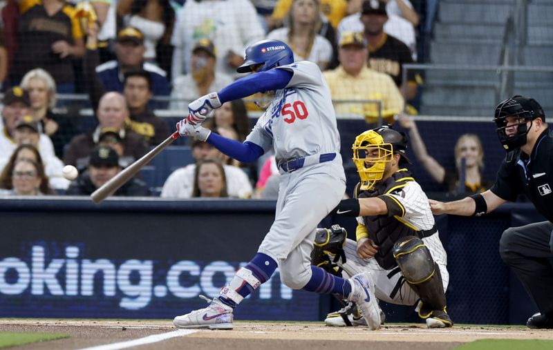 Oct 9, 2024; San Diego, California, USA; Los Angeles Dodgers shortstop Mookie Betts (50) hits a home run in the first inning against the San Diego Padres during game four of the NLDS for the 2024 MLB Playoffs at Petco Park. Mandatory Credit: David Frerker-Imagn Images