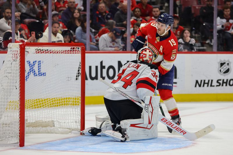 Nov 14, 2024; Sunrise, Florida, USA; Florida Panthers left wing Matthew Tkachuk (19) hits the post against New Jersey Devils goaltender Jake Allen (34) during the second period at Amerant Bank Arena. Mandatory Credit: Sam Navarro-Imagn Images