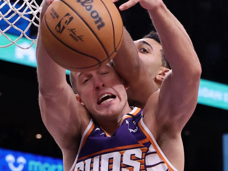 PHOENIX, ARIZONA - NOVEMBER 30: Mason Plumlee #22 of the Phoenix Suns and Trayce Jackson-Davis #32 of the Golden State Warriors battle for a rebound during the first half at Footprint Center on November 30, 2024 in Phoenix, Arizona. NOTE TO USER: User expressly acknowledges and agrees that, by downloading and or using this photograph, User is consenting to the terms and conditions of the Getty Images License Agreement.  (Photo by Chris Coduto/Getty Images)