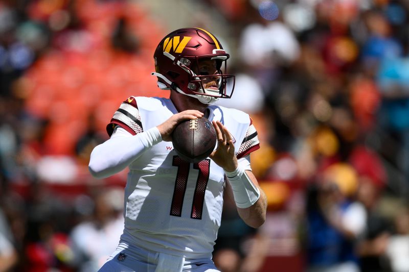 Washington Commanders quarterback Carson Wentz (11) in action during the first half of a preseason NFL football game against the Carolina Panthers, Saturday, Aug. 13, 2022, in Landover, Md. (AP Photo/Nick Wass)