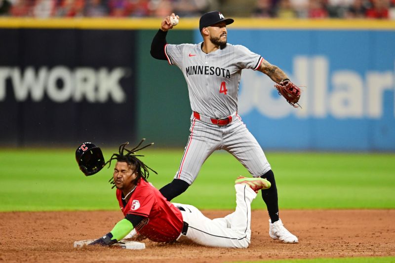 Sep 16, 2024; Cleveland, Ohio, USA; Minnesota Twins shortstop Carlos Correa (4) forces out Cleveland Guardians third baseman Jose Ramirez (11) and turns the double play during the sixth inning at Progressive Field. Mandatory Credit: Ken Blaze-Imagn Images