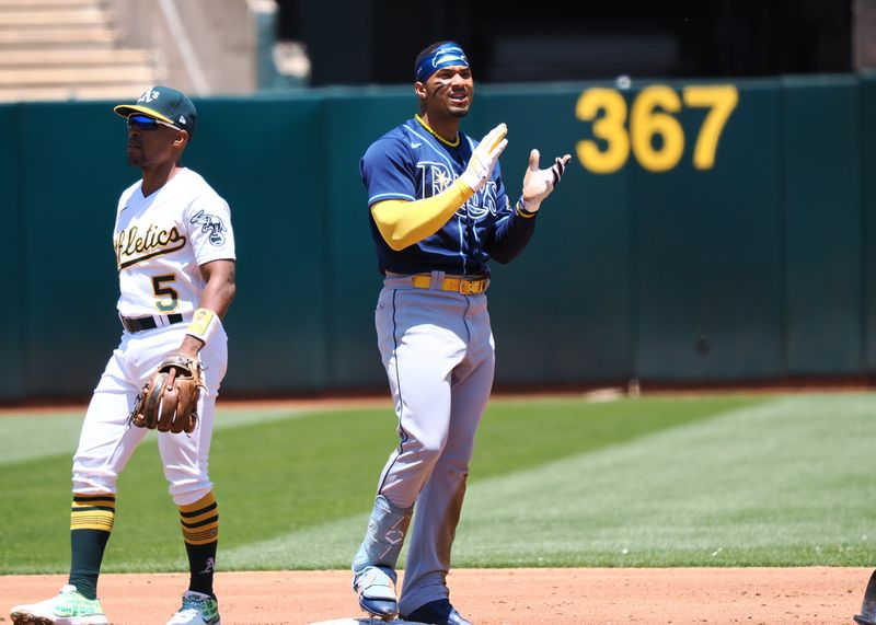 Jun 15, 2023; Oakland, California, USA; Tampa Bay Rays shortstop Wander Franco (5) claps behind Oakland Athletics second baseman Tony Kemp (5) after sliding for a double during the third inning at Oakland-Alameda County Coliseum. Mandatory Credit: Kelley L Cox-USA TODAY Sports