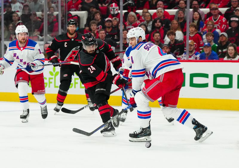 May 16, 2024; Raleigh, North Carolina, USA; New York Rangers defenseman Braden Schneider (4) blocks the shot by Carolina Hurricanes center Seth Jarvis (24) during the first period in game six of the second round of the 2024 Stanley Cup Playoffs at PNC Arena. Mandatory Credit: James Guillory-USA TODAY Sports