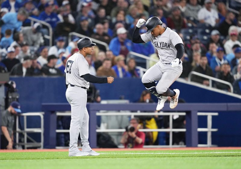 Apr 17, 2024; Toronto, Ontario, CAN; New York Yankees right fielder Juan Soto (22) hits a home run and celebrates with third base coach Luis Rojas (67) against the Toronto Blue Jays during the eighth inning at Rogers Centre. Mandatory Credit: Nick Turchiaro-USA TODAY Sports