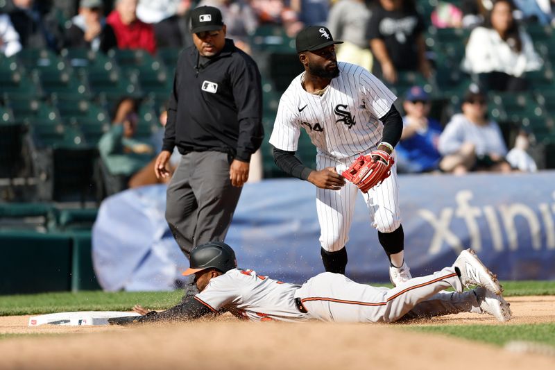 May 26, 2024; Chicago, Illinois, USA; Baltimore Orioles outfielder Cedric Mullins (31) advances to third base against Chicago White Sox third baseman Bryan Ramos (44) during the ninth inning at Guaranteed Rate Field. Mandatory Credit: Kamil Krzaczynski-USA TODAY Sports