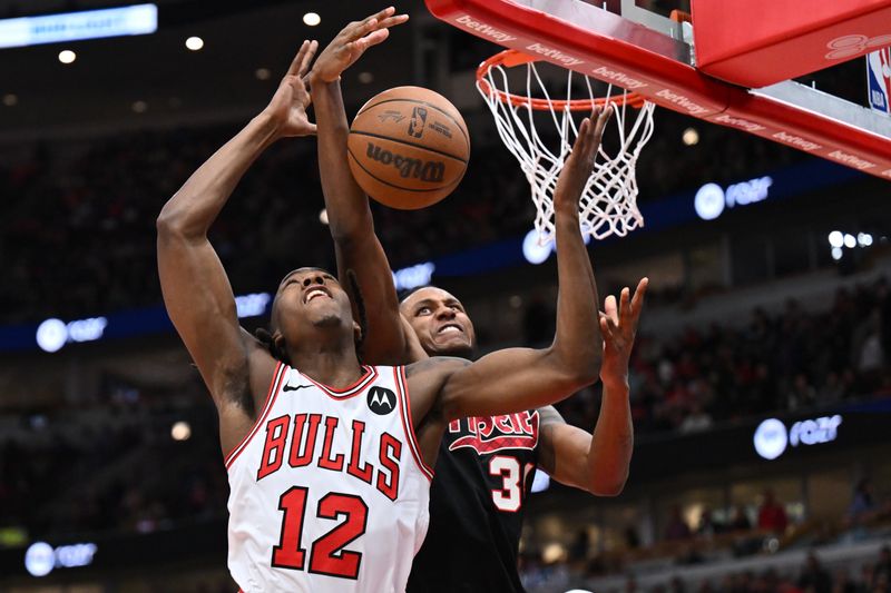 CHICAGO, ILLINOIS - MARCH 18:  Ayo Dosunmu #12 of the Chicago Bulls and Jabari Walker #34 of the Portland Trail Blazers battle for a rebound in the first half on March 18, 2024 at United Center in Chicago, Illinois.   NOTE TO USER: User expressly acknowledges and agrees that, by downloading and or using this photograph, User is consenting to the terms and conditions of the Getty Images License Agreement.  (Photo by Jamie Sabau/Getty Images)