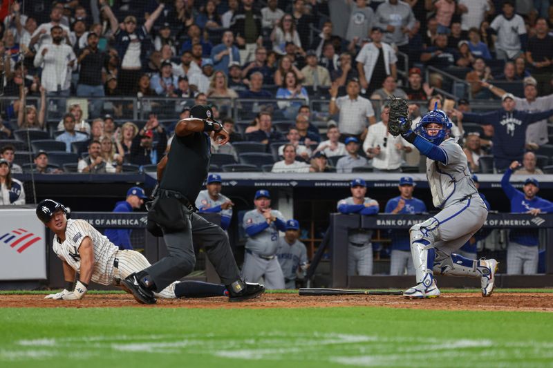 Sep 11, 2024; Bronx, New York, USA; Kansas City Royals catcher Freddy Fermin (34) reacts after tagging out New York Yankees shortstop Anthony Volpe (11) during the seventh inning to complete a double play at Yankee Stadium. Mandatory Credit: Vincent Carchietta-Imagn Images