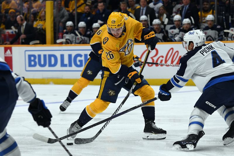 Nov 26, 2023; Nashville, Tennessee, USA; Nashville Predators center Philip Tomasino (26) has the puck knocked off his stick by Winnipeg Jets defenseman Neal Pionk (4) during the first period at Bridgestone Arena. Mandatory Credit: Christopher Hanewinckel-USA TODAY Sports