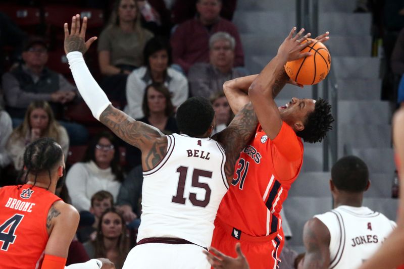 Jan 27, 2024; Starkville, Mississippi, USA; Auburn Tigers forward Chaney Johnson (31) shoots as Mississippi State Bulldogs forward Jimmy Bell Jr. (15) defends during the second half at Humphrey Coliseum. Mandatory Credit: Petre Thomas-USA TODAY Sports