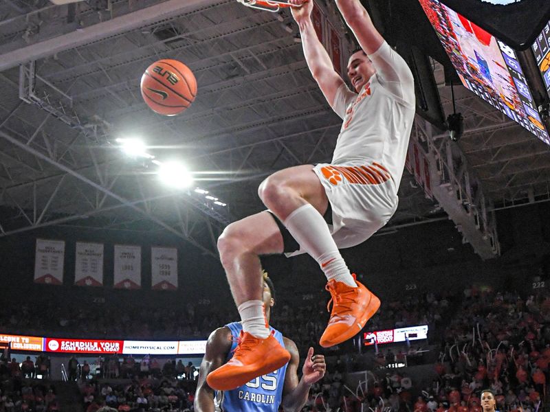 Jan 6, 2024; Clemson, South Carolina, USA; Clemson junior forward Ian Schieffelin (4) dunks near University of North Carolina forward Harrison Ingram (55) during the second half  at Littlejohn Coliseum. Mandatory Credit: Ken Ruinard-USA TODAY Sports