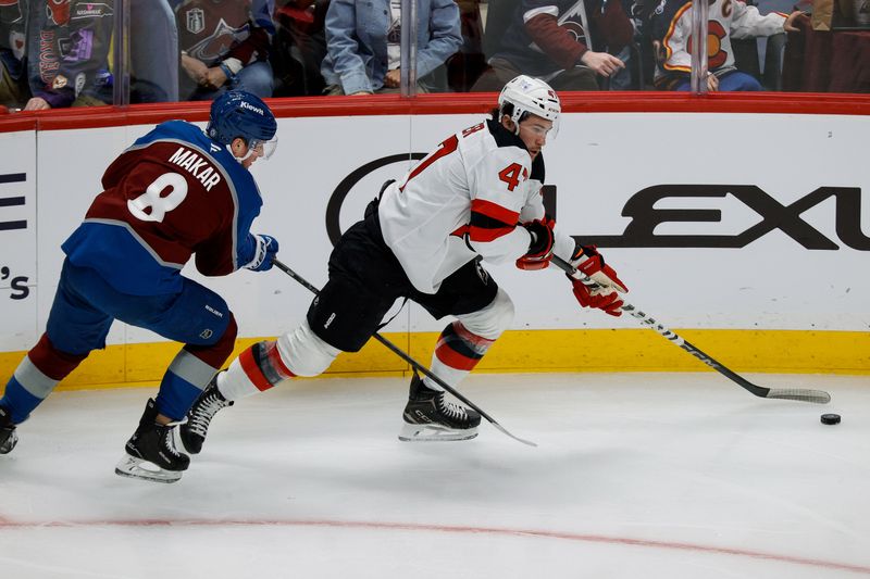 Feb 26, 2025; Denver, Colorado, USA; New Jersey Devils center Paul Cotter (47) controls the puck ahead of Colorado Avalanche defenseman Cale Makar (8) in the first period at Ball Arena. Mandatory Credit: Isaiah J. Downing-Imagn Images