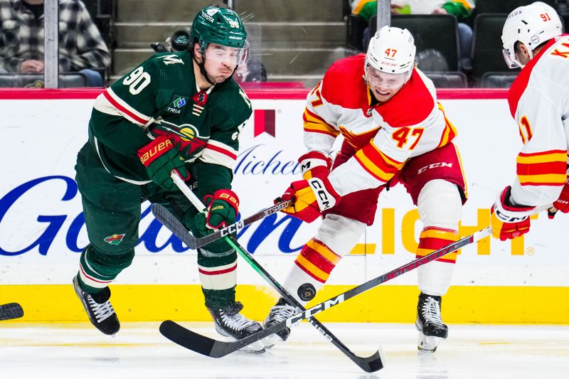 Jan 2, 2024; Saint Paul, Minnesota, USA; Calgary Flames center Connor Zary (47) defends Minnesota Wild left wing Marcus Johansson (90) during the second period at Xcel Energy Center. Mandatory Credit: Brace Hemmelgarn-USA TODAY Sports