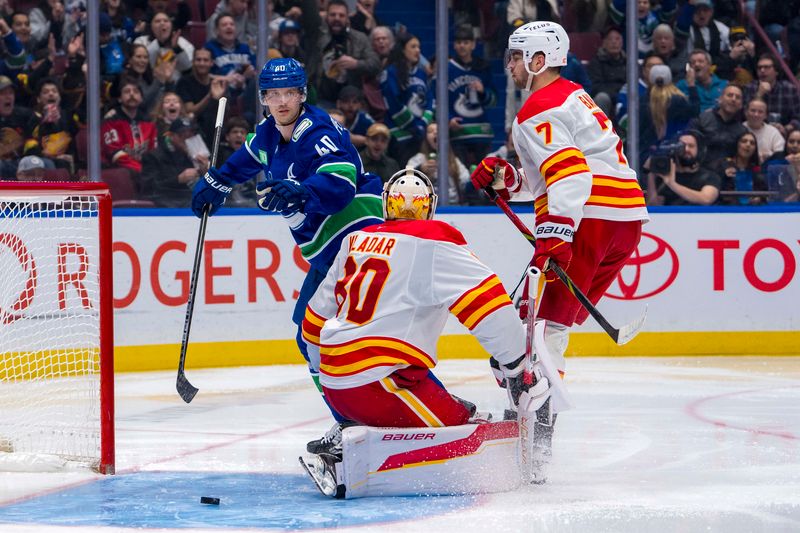 Nov 12, 2024; Vancouver, British Columbia, CAN; Calgary Flames goalie Dan Vladar (80) and defenseman Kevin Bahl (7) react as Vancouver Canucks forward Elias Pettersson (40) celebrates his goal during the second period at Rogers Arena. Mandatory Credit: Bob Frid-Imagn Images