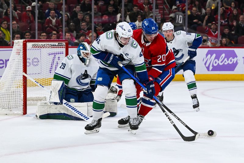 Nov 12, 2023; Montreal, Quebec, CAN; Vancouver Canucks defenseman Quinn Hughes (43) defends the puck against Montreal Canadiens left wing Juraj Slafkovsky (20) during the second period at Bell Centre. Mandatory Credit: David Kirouac-USA TODAY Sports