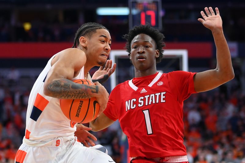 Feb 14, 2023; Syracuse, New York, USA; Syracuse Orange guard Judah Mintz (3) drives to the basket against the defense of North Carolina State Wolfpack guard Jarkel Joiner (1) during the first half at the JMA Wireless Dome. Mandatory Credit: Rich Barnes-USA TODAY Sports