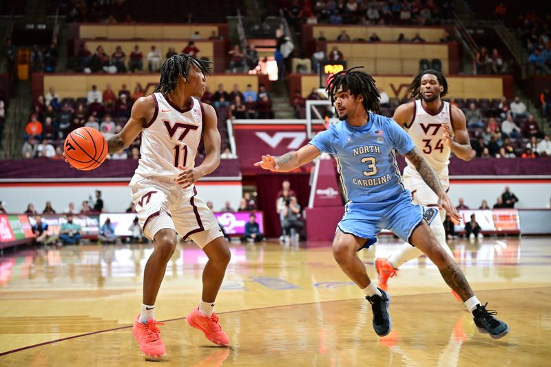 Mar 4, 2025; Blacksburg, Virginia, USA;  Virginia Tech Hokies guard Ben Hammond (11) handles the ball as North Carolina Tar Heels guard Elliot Cadeau (3) defends during the first half at Cassell Coliseum. Mandatory Credit: Brian Bishop-Imagn Images