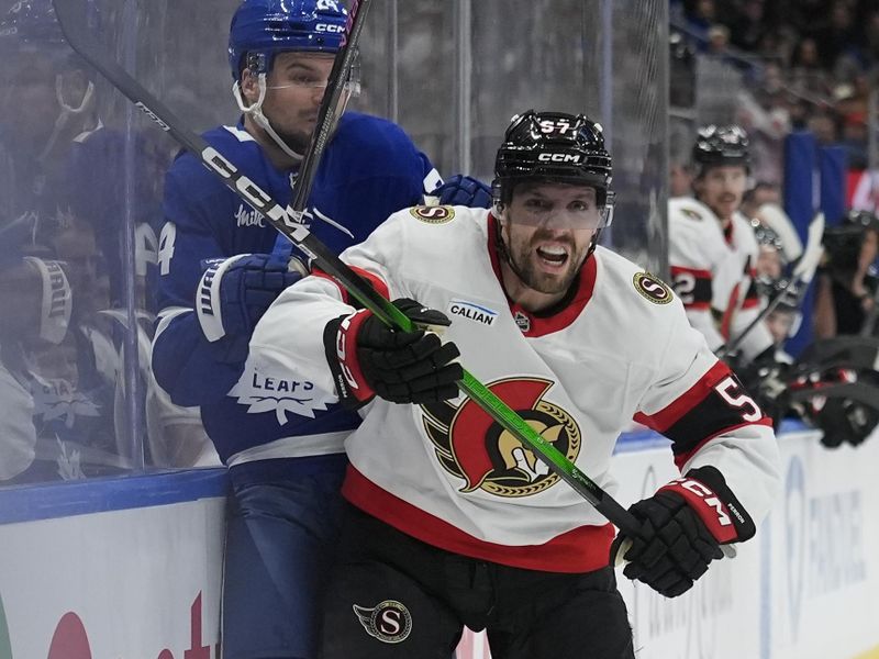 Dec 27, 2025; Toronto, Ontario, CAN; Ottawa Senators forward David Perron (57) checks Toronto Maple Leafs forward Scott Laughton (24) into the boards during the first period at Scotiabank Arena. Mandatory Credit: John E. Sokolowski-Imagn Images
