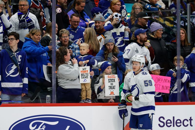 Oct 30, 2024; Denver, Colorado, USA; Tampa Bay Lightning fans stand at the glass with signs as center Jake Guentzel (59) skates by before the game against the Colorado Avalanche at Ball Arena. Mandatory Credit: Isaiah J. Downing-Imagn Images