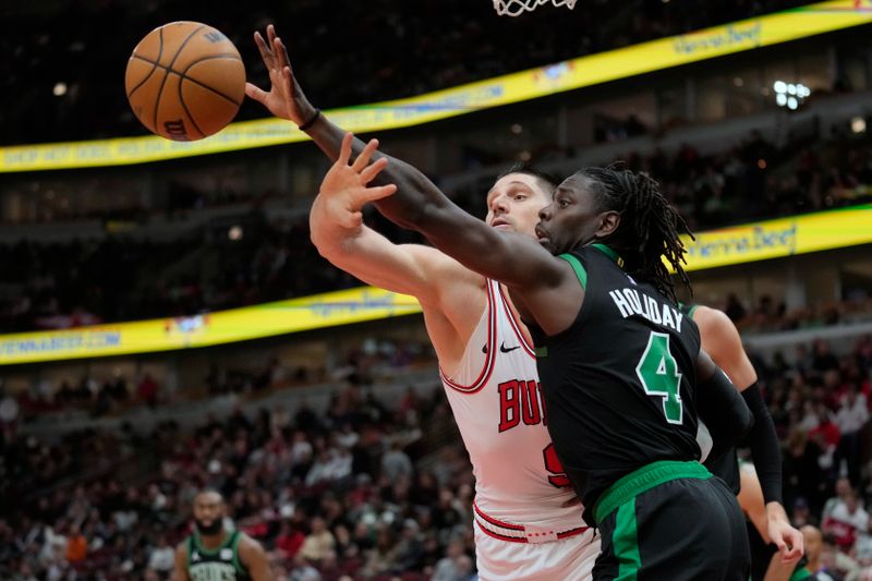 CHICAGO, ILLINOIS - FEBRUARY 22: Nikola Vucevic #9 of the Chicago Bulls and Jrue Holiday #4 of the Boston Celtics go for a rebound during the second half at the United Center on February 22, 2024 in Chicago, Illinois. NOTE TO USER: User expressly acknowledges and agrees that, by downloading and or using this photograph, User is consenting to the terms and conditions of the Getty Images License Agreement. (Photo by Patrick McDermott/Getty Images)