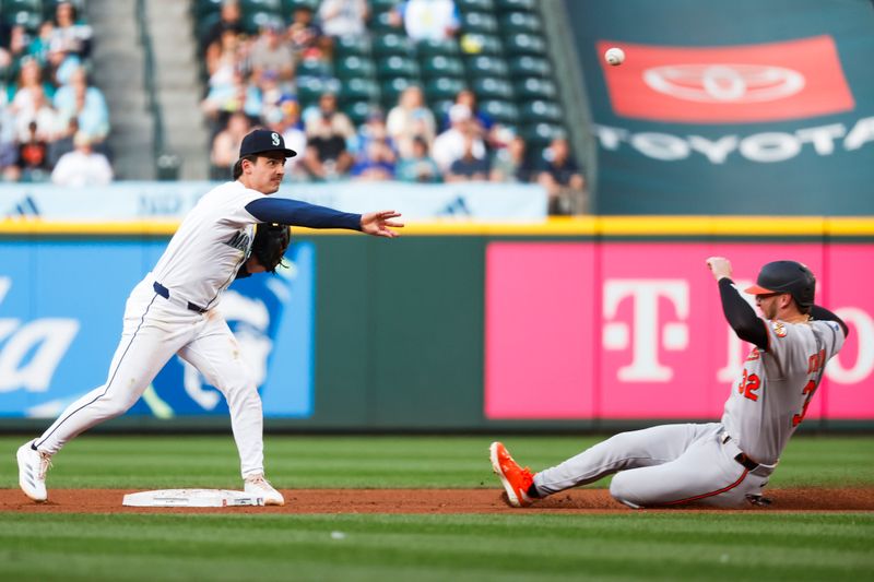 Jun 3, 2025; Seattle, Washington, USA; Seattle Mariners second baseman Cole Young (2) turns a double play against Baltimore Orioles first baseman Ryan O'Hearn (32)  during the third inning at T-Mobile Park. Mandatory Credit: Joe Nicholson-Imagn Images