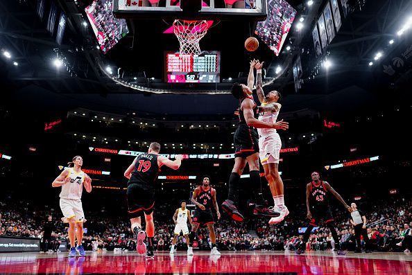 TORONTO, ON - DECEMBER 23: John Collins #20 of the Utah Jazz shoots against Scottie Barnes #4 of the Toronto Raptors during the first half of their basketball game at the Scotiabank Arena on December 23, 2023 in Toronto, Ontario, Canada. NOTE TO USER: User expressly acknowledges and agrees that, by downloading and/or using this Photograph, user is consenting to the terms and conditions of the Getty Images License Agreement. (Photo by Mark Blinch/Getty Images)