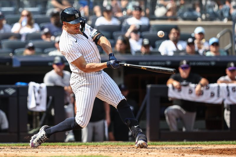 Aug 25, 2024; Bronx, New York, USA;  New York Yankees designated hitter Giancarlo Stanton (27) hits a single in the fifth inning against the Colorado Rockies at Yankee Stadium. Mandatory Credit: Wendell Cruz-USA TODAY Sports