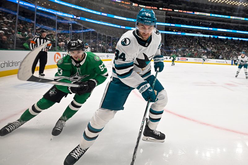 Nov 20, 2024; Dallas, Texas, USA; San Jose Sharks defenseman Jan Rutta (84) clears the puck in front of Dallas Stars center Wyatt Johnston (53) during the second period at the American Airlines Center. Mandatory Credit: Jerome Miron-Imagn Images