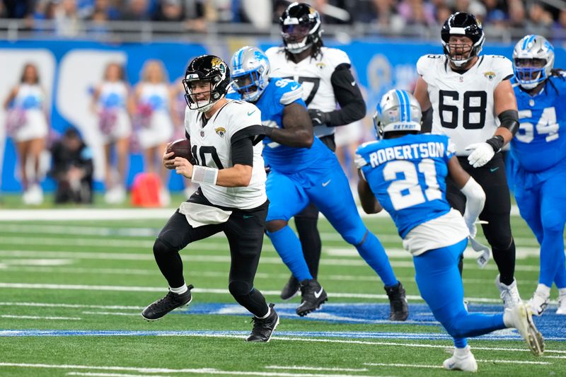 Jacksonville Jaguars quarterback Mac Jones (10) runs the ball against the Detroit Lions during the first half of an NFL football game, Sunday, Nov. 17, 2024, in Detroit. (AP Photo/Carlos Osorio)