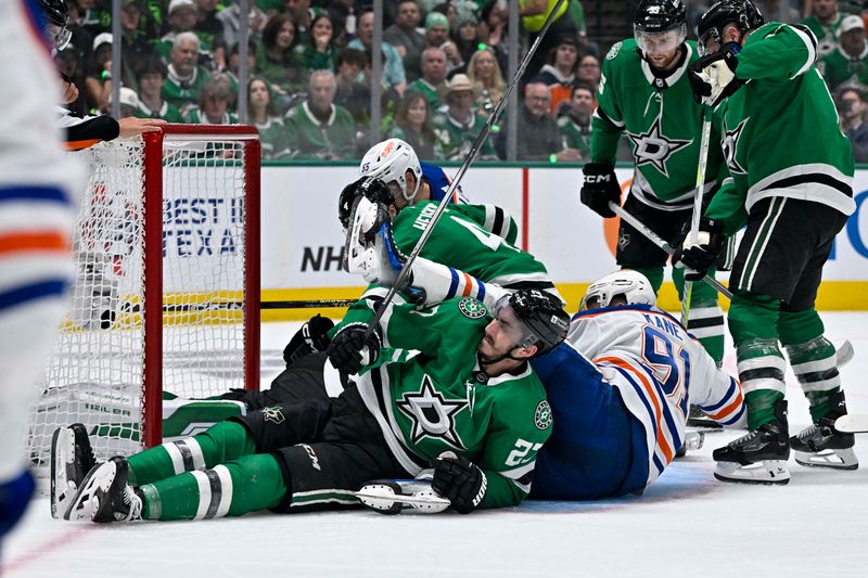 May 25, 2024; Dallas, Texas, USA; Dallas Stars left wing Mason Marchment (27) and defenseman Miro Heiskanen (4) and Edmonton Oilers left wing Evander Kane (91) and left wing Dylan Holloway (55) collide into the Stars goal during the first period in game two of the Western Conference Final of the 2024 Stanley Cup Playoffs at American Airlines Center. Mandatory Credit: Jerome Miron-USA TODAY Sports