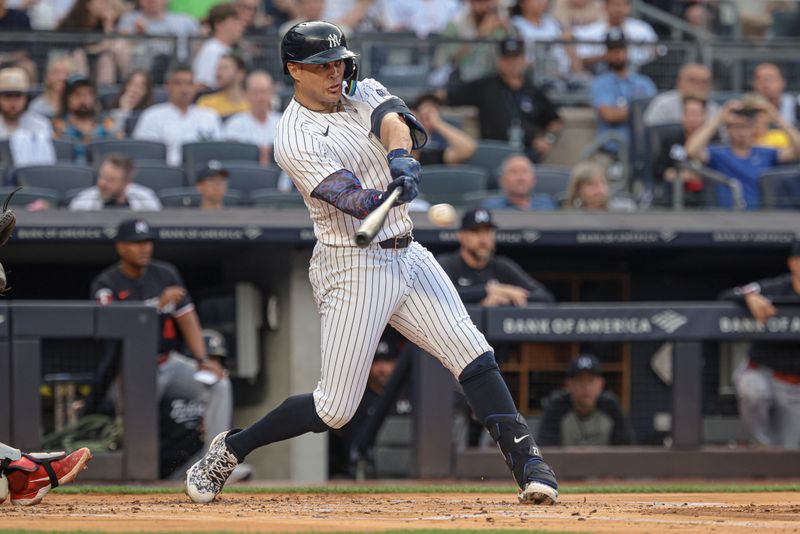 Jun 5, 2024; Bronx, New York, USA; New York Yankees designated hitter Giancarlo Stanton (27) hits an RBI single during the first inning against the Minnesota Twins at Yankee Stadium. Mandatory Credit: Vincent Carchietta-USA TODAY Sports