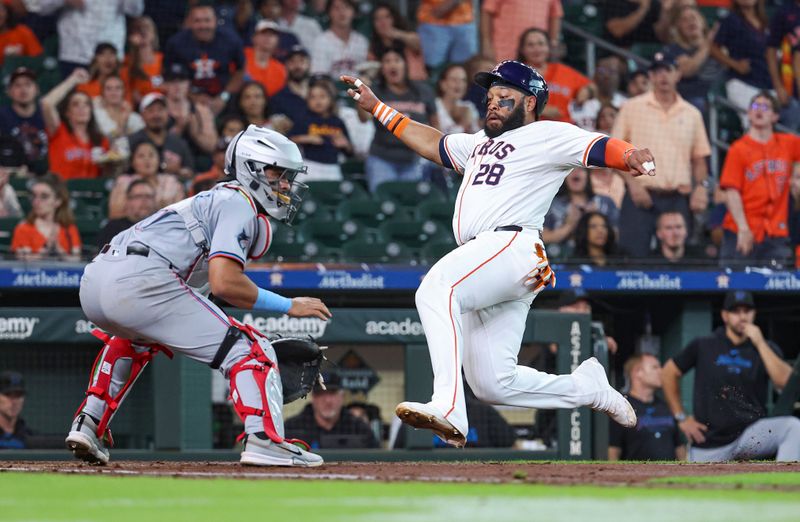 Jul 10, 2024; Houston, Texas, USA; Houston Astros first baseman Jon Singleton (28) slides safely past Miami Marlins catcher Ali Sanchez (47) to score a run during the second inning at Minute Maid Park. Mandatory Credit: Troy Taormina-USA TODAY Sports