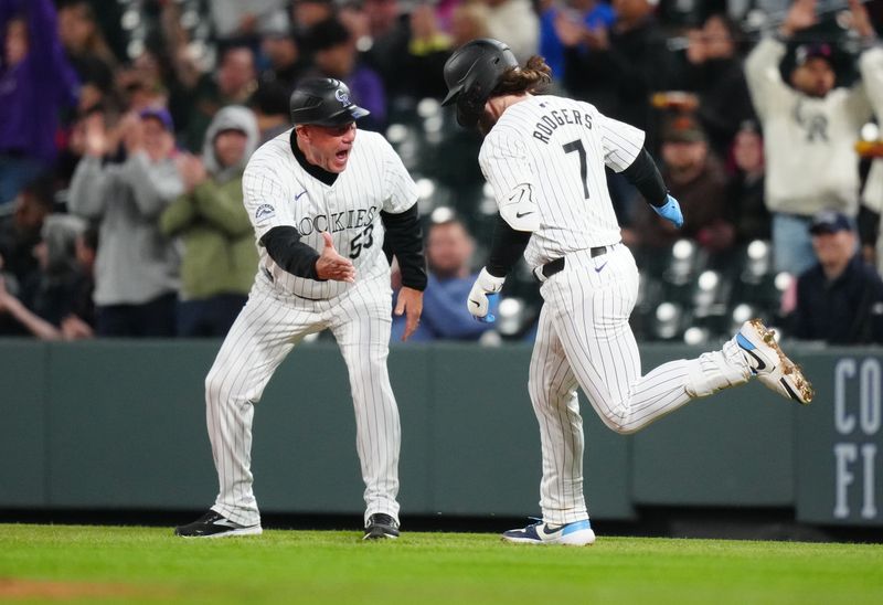 Apr 23, 2024; Denver, Colorado, USA; Colorado Rockies second base Brendan Rodgers (7) is congratulated by first base coach Ronnie Gideon (53) for his grand slam in the fourth inning against the San Diego Padres at Coors Field. Mandatory Credit: Ron Chenoy-USA TODAY Sports