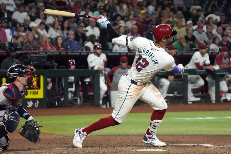 Jul 8, 2024; Phoenix, Arizona, USA; Arizona Diamondbacks outfielder Lourdes Gurriel Jr. (12) hits a sacrifice fly out against the Atlanta Braves in the sixth inning at Chase Field. Mandatory Credit: Rick Scuteri-USA TODAY Sports