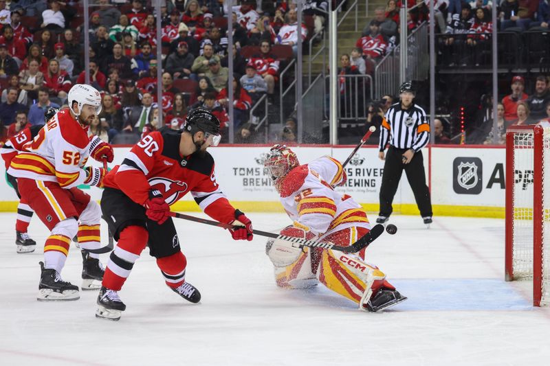 Mar 20, 2025; Newark, New Jersey, USA; Calgary Flames goaltender Dustin Wolf (32) makes a save on New Jersey Devils left wing Tomas Tatar (90) during the second period at Prudential Center. Mandatory Credit: Ed Mulholland-Imagn Images