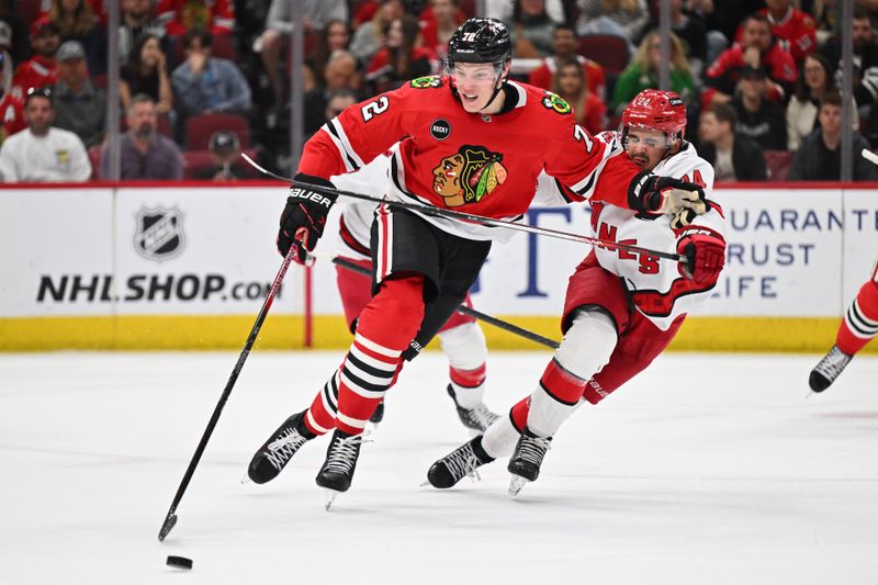 Apr 14, 2024; Chicago, Illinois, USA;  Chicago Blackhawks defenseman Alex Vlasic (72) fends off Carolina Hurricanes forward Seth Jarvis (24) while controlling the puck in the second period at United Center. Mandatory Credit: Jamie Sabau-USA TODAY Sports