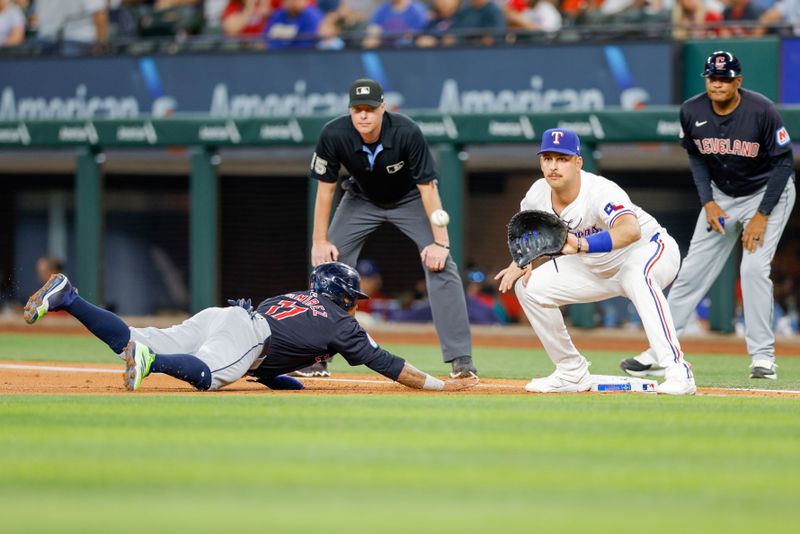 May 15, 2024; Arlington, Texas, USA; Cleveland Guardians third base Jose Ramírez (11) slides back under the throw to Texas Rangers first base Nathaniel Lowe (30) during the first inning at Globe Life Field. Mandatory Credit: Andrew Dieb-USA TODAY Sports