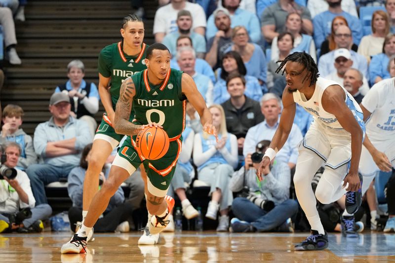 Feb 26, 2024; Chapel Hill, North Carolina, USA; Miami (Fl) Hurricanes guard Matthew Cleveland (0) dribbles as North Carolina Tar Heels forward Jae'Lyn Withers (24) defends in the first half at Dean E. Smith Center. Mandatory Credit: Bob Donnan-USA TODAY Sports