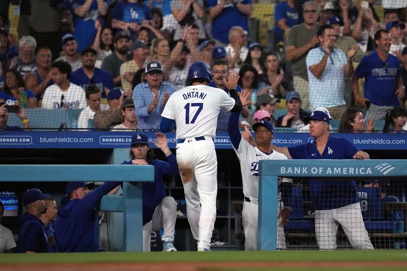 Aug 21, 2024; Los Angeles, California, USA; Los Angeles Dodgers designated hitter Shohei Ohtani (17) is greeted by manager Dave Roberts (30) after scoring in the fifth inning against the Seattle Mariners at Dodger Stadium. Mandatory Credit: Kirby Lee-USA TODAY Sports