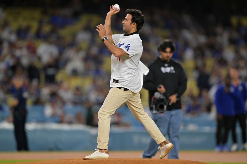 Sep 17, 2025; Los Angeles, California, USA;  Formula 1 driver Sergio “Checo” Perez throws out the first pitch prior to the game between the Los Angeles Dodgers and the Philadelphia Phillies at Dodger Stadium. Mandatory Credit: Jayne Kamin-Oncea-Imagn Images