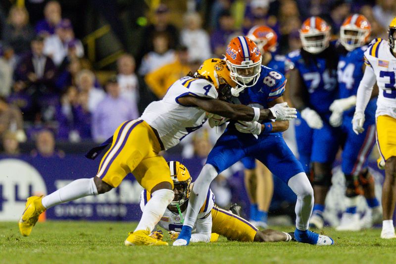 Nov 11, 2023; Baton Rouge, Louisiana, USA; LSU Tigers linebacker Harold Perkins Jr. (4) tackles Florida Gators wide receiver Marcus Burke (88) during the second half at Tiger Stadium. Mandatory Credit: Stephen Lew-USA TODAY Sports