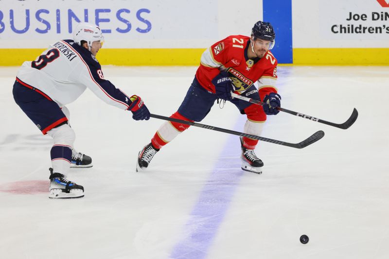 Apr 11, 2024; Sunrise, Florida, USA; Florida Panthers center Nick Cousins (21) passes the puck as Columbus Blue Jackets defenseman Zach Werenski (8) defends during the first period at Amerant Bank Arena. Mandatory Credit: Sam Navarro-USA TODAY Sports