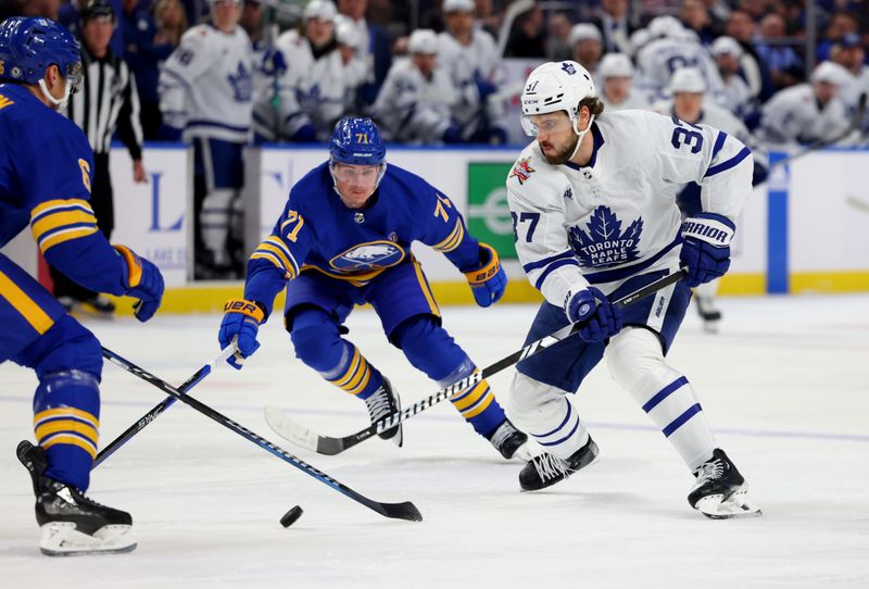 Dec 21, 2023; Buffalo, New York, USA;  Toronto Maple Leafs defenseman Timothy Liljegren (37) skates with the puck as Buffalo Sabres left wing Victor Olofsson (71) defends during the first period at KeyBank Center. Mandatory Credit: Timothy T. Ludwig-USA TODAY Sports