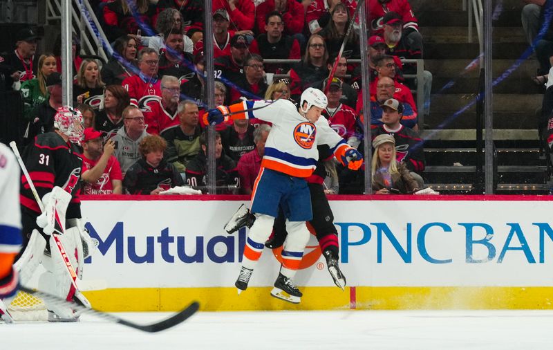 Apr 20, 2024; Raleigh, North Carolina, USA; New York Islanders left wing Matt Martin (17) checks Carolina Hurricanes center Jack Drury (18) during the first period in game one of the first round of the 2024 Stanley Cup Playoffs at PNC Arena. Mandatory Credit: James Guillory-USA TODAY Sports